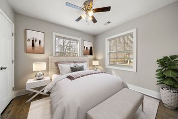 A bedroom with a bed, a ceiling fan, and two lamps with window